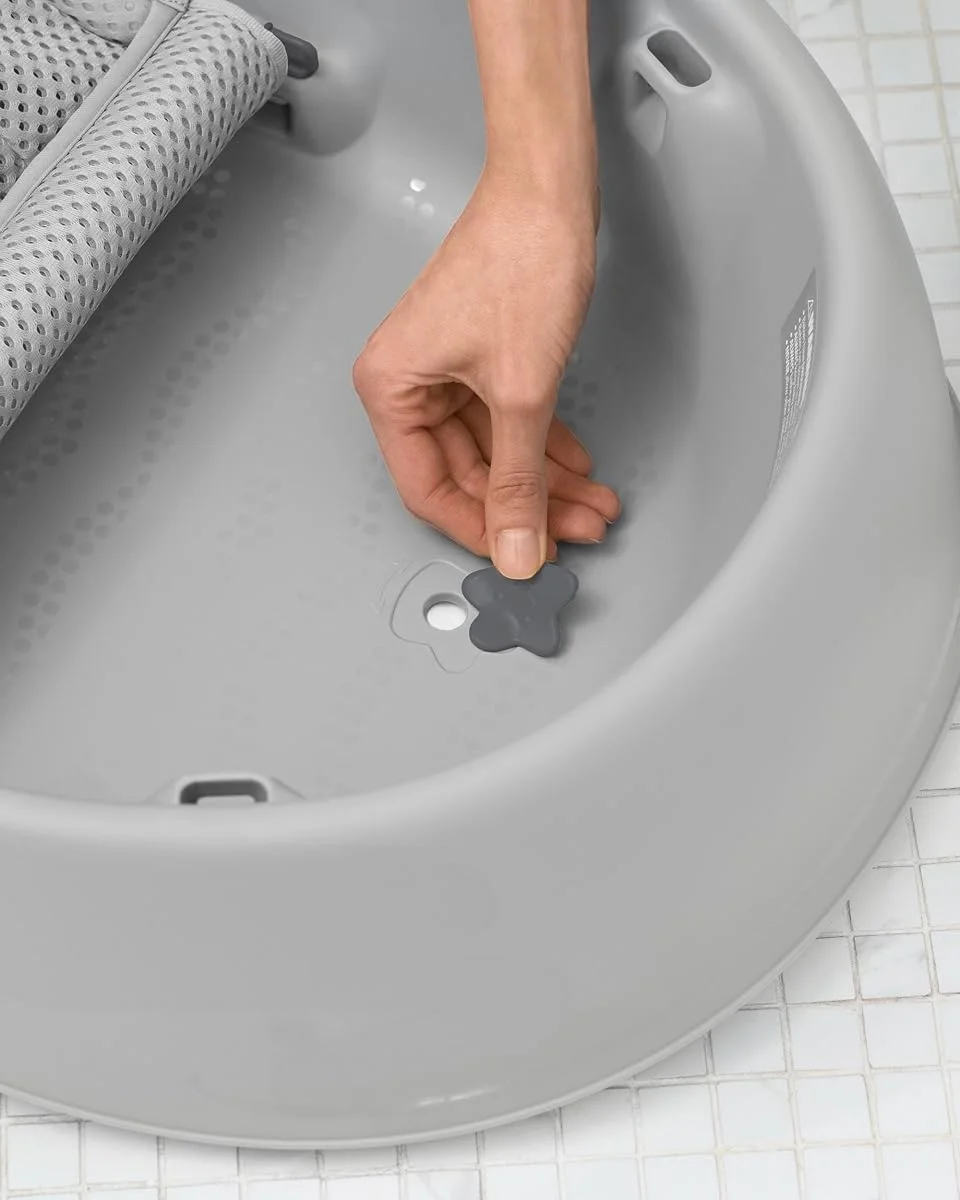 Close-up of the grey flower-shaped drain plug on the Skip Hop Moby baby bathtub