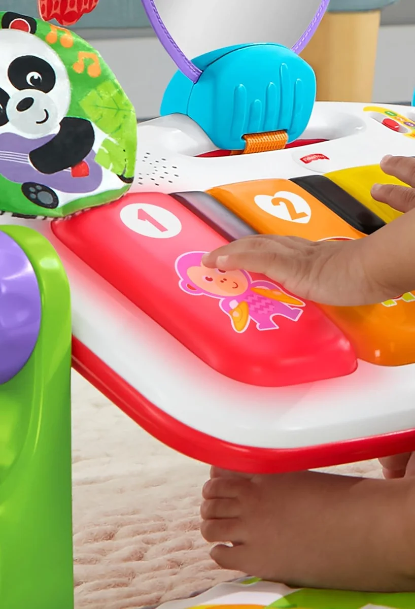 Close-up of the light-up piano keys and hanging panda toy on the Fisher-Price Deluxe Kick & Play Piano Gym