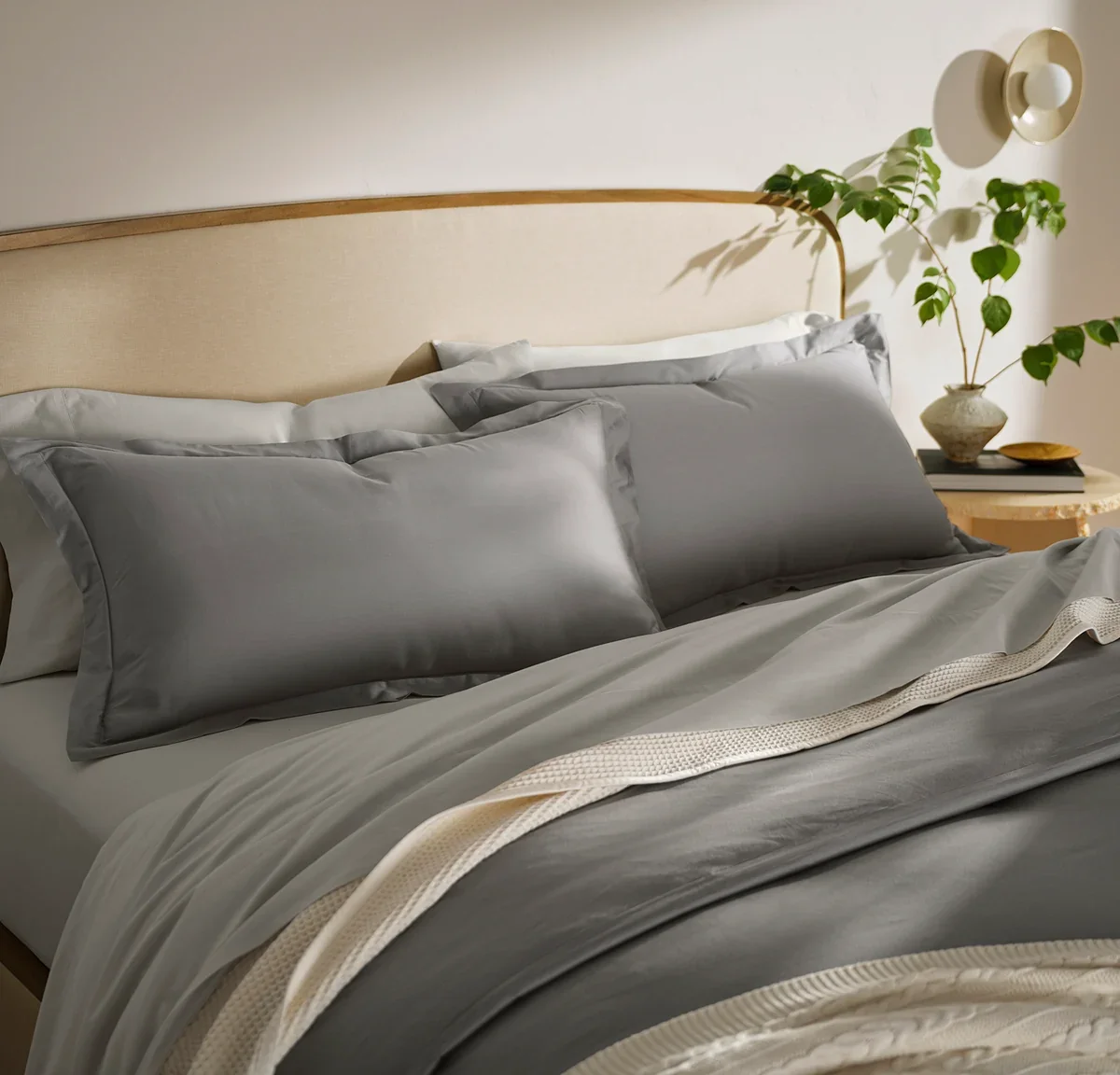 Close-up of the Boll & Branch Signature Hemmed shams and duvet in Stone showing the organic cotton sateen weave and hemmed edge