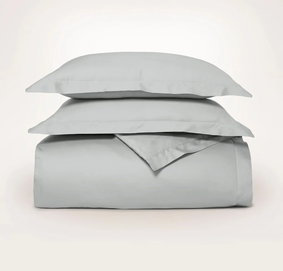 Boll & Branch Signature Hemmed Duvet Set in Shore, folded and styled with matching shams in an alternate color