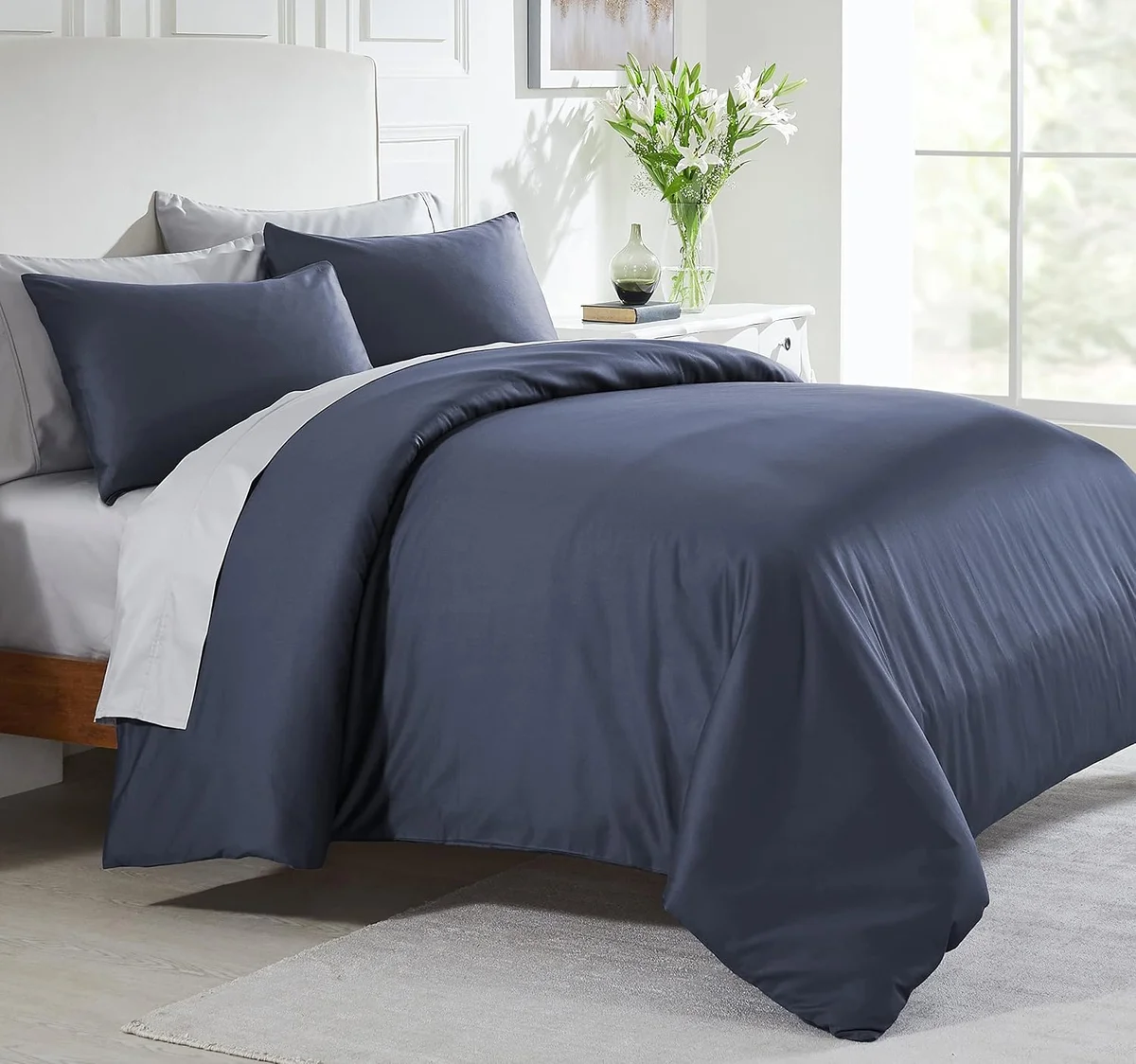 California Design Den sateen duvet cover in navy on a full made bed with matching pillow shams
