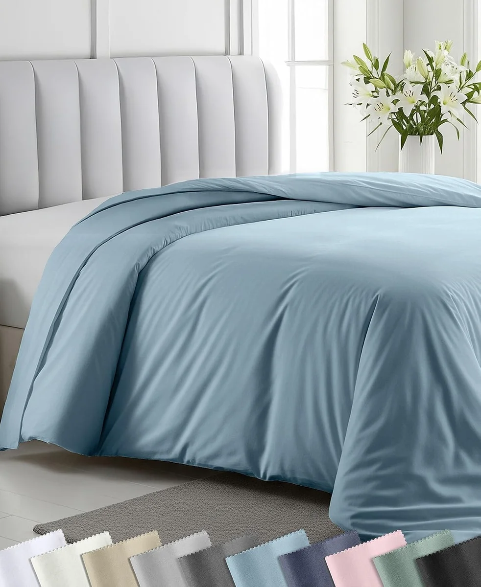 California Design Den 400 thread count sateen duvet cover in blue draped over a bed