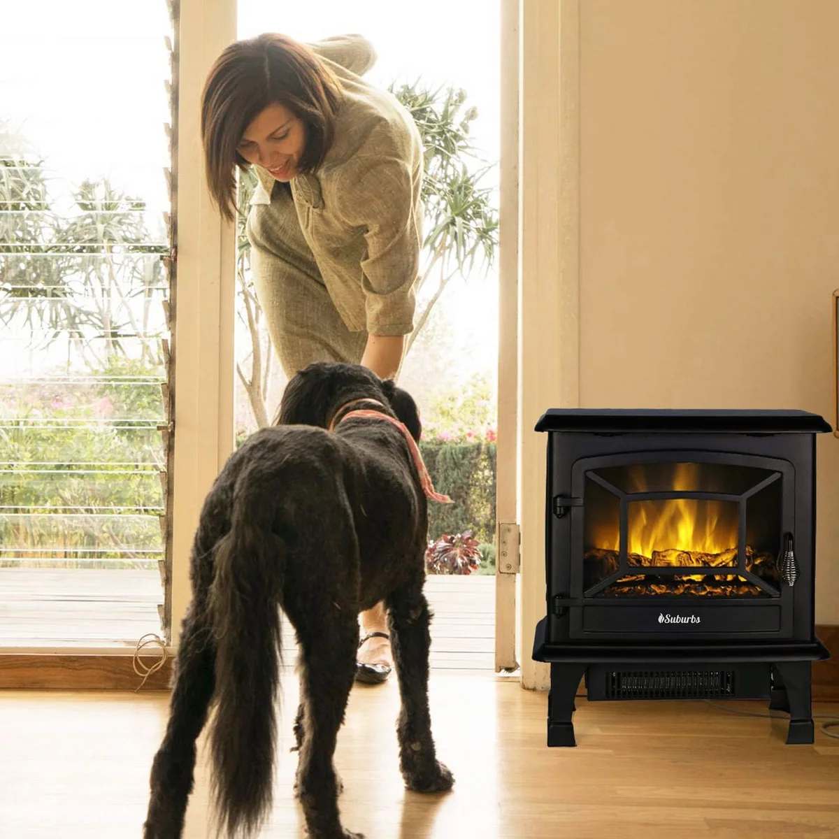 TURBRO Suburbs TS20 electric fireplace stove in a bright living room with a woman and dog nearby, showing its compact freestanding size in use