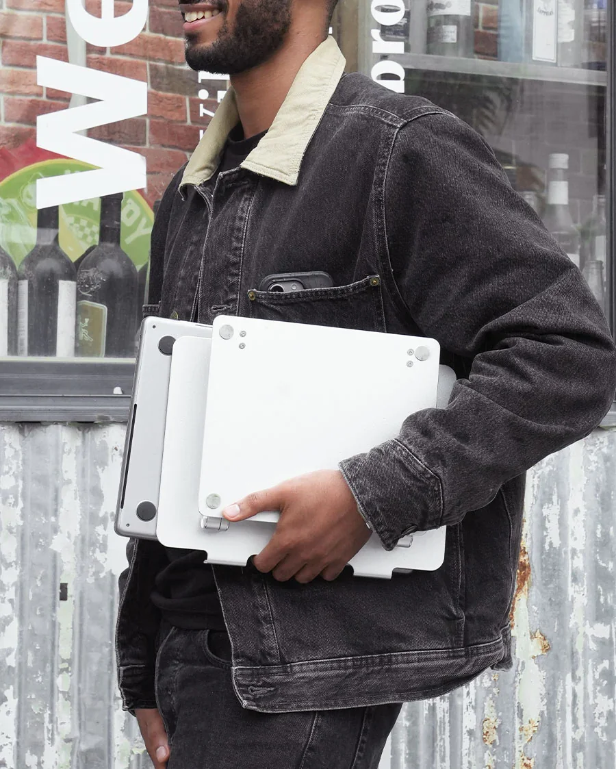 Lamicall stand folded flat with laptop, carried outdoors showing portability