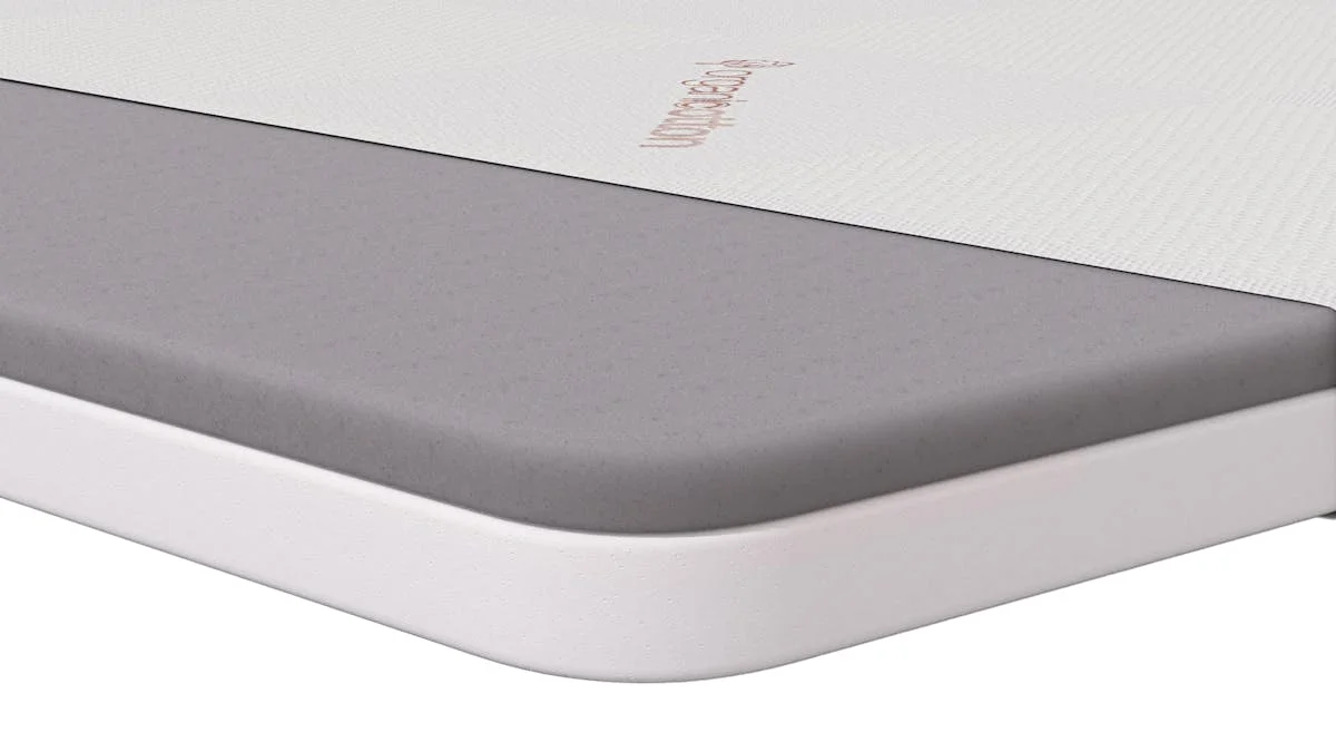 Saatva Graphite Memory Foam Mattress Topper corner cross-section studio shot showing the graphite-infused foam layer and quilted cover
