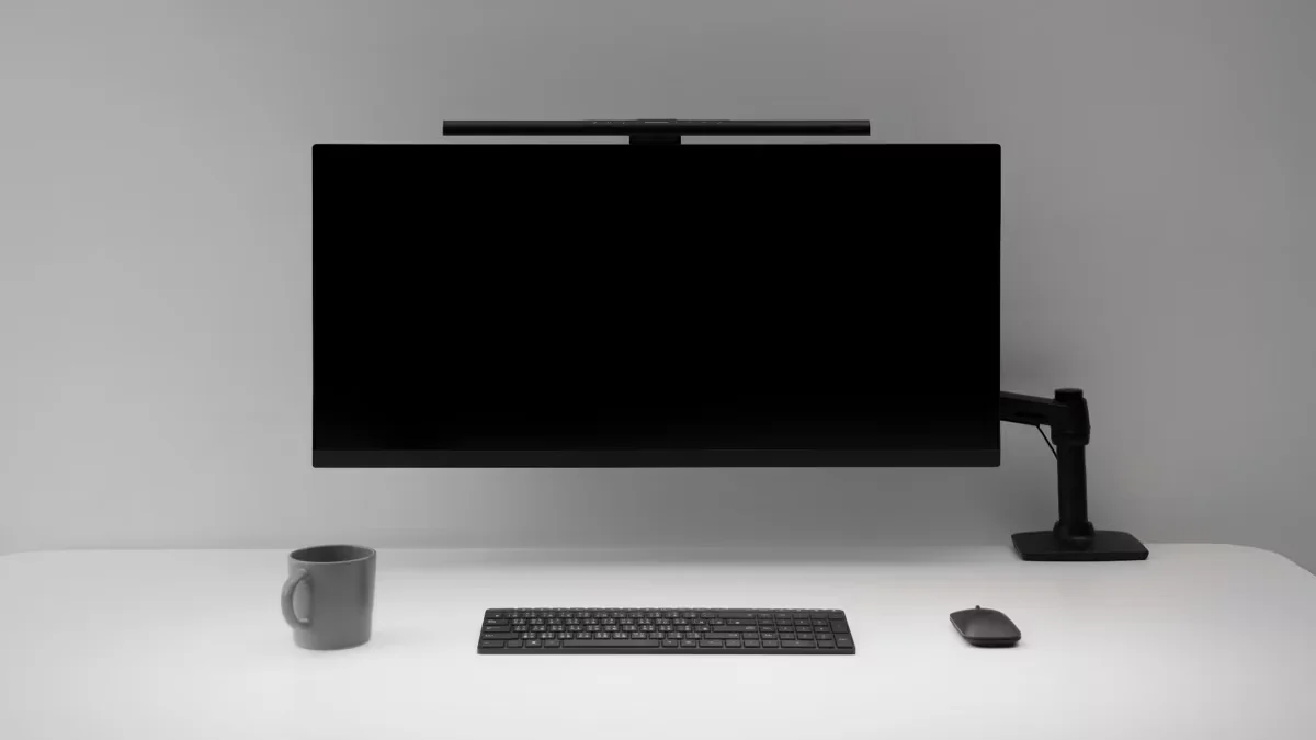 BenQ ScreenBar Pro mounted on a monitor arm above a minimal desk setup, front view