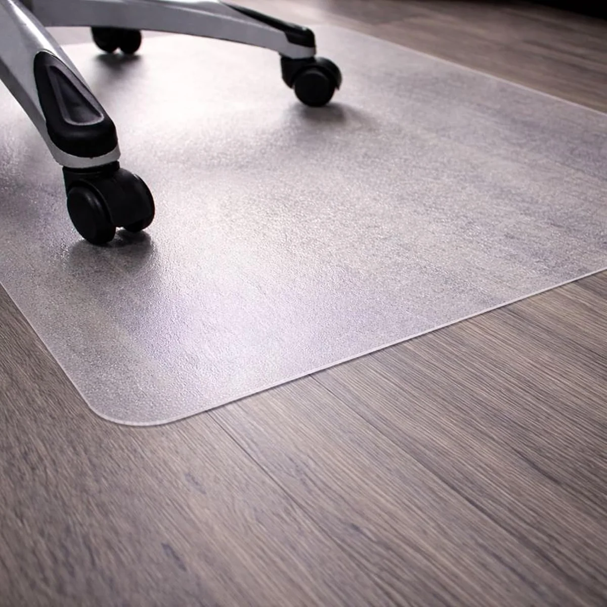 Corner of the Marvelux clear chair mat with an office chair caster resting on it