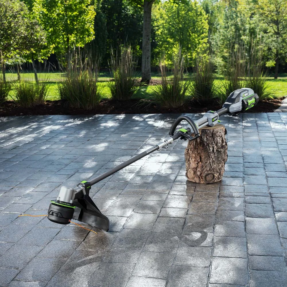 EGO Power+ ST1623T trimmer resting on patio in outdoor garden setting
