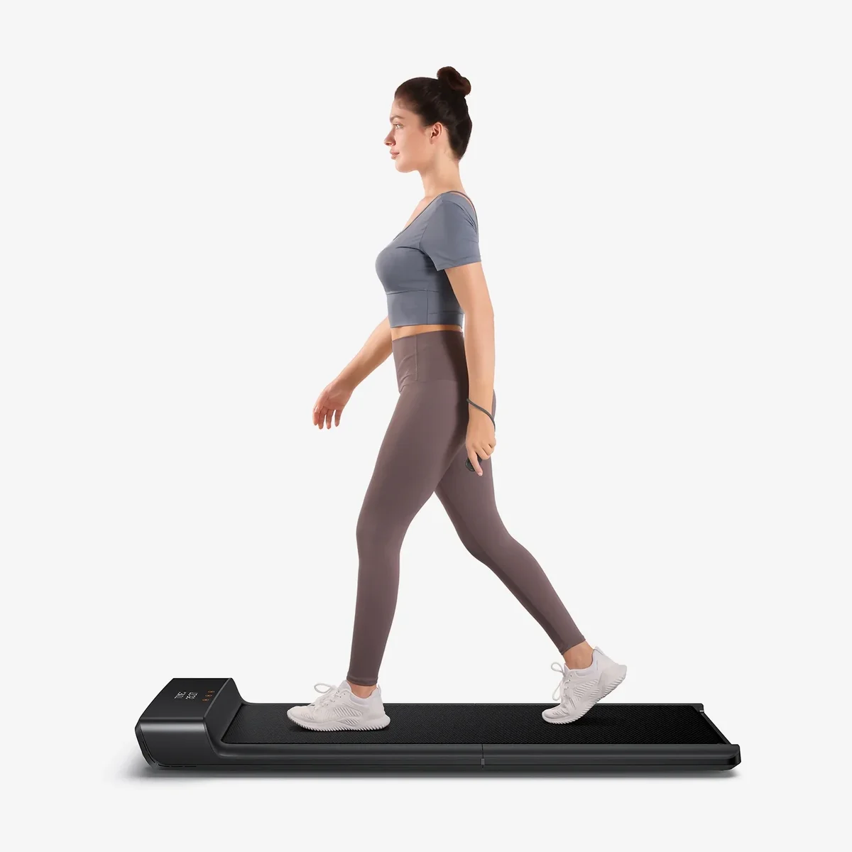 Person walking on WalkingPad A1 Pro treadmill on light background, lifestyle view