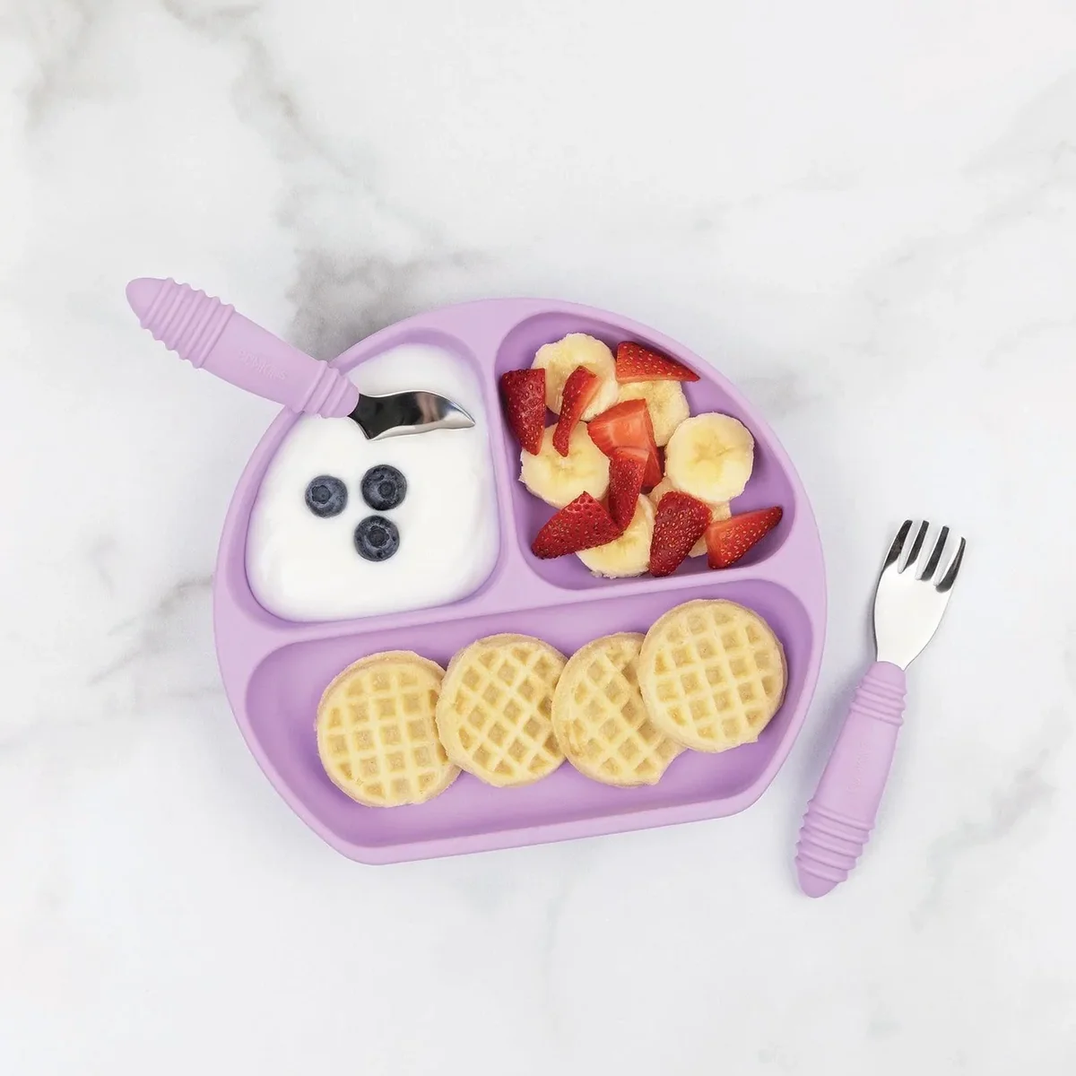 Bumkins Silicone Grip Dish in lavender filled with waffles, strawberries, banana, and yogurt on a marble surface