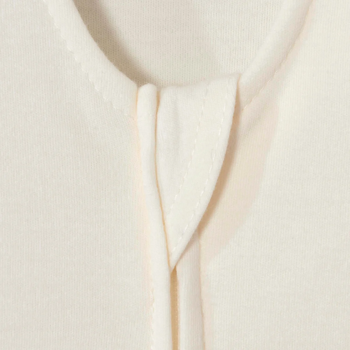 Halo SleepSack cream cotton close-up showing the zipper cover and neckline stitching