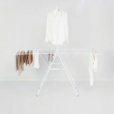 Brabantia HangOn drying rack in use, loaded with laundry across the wings and a shirt hung on the top rod
