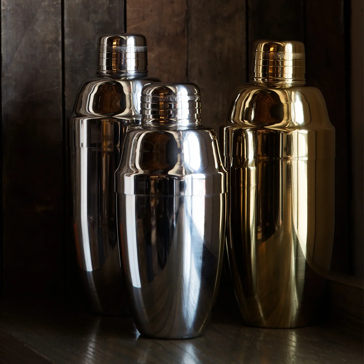 Stainless Usagi Cobbler Shaker beside gold and stainless Usagi shakers on a dark wood shelf
