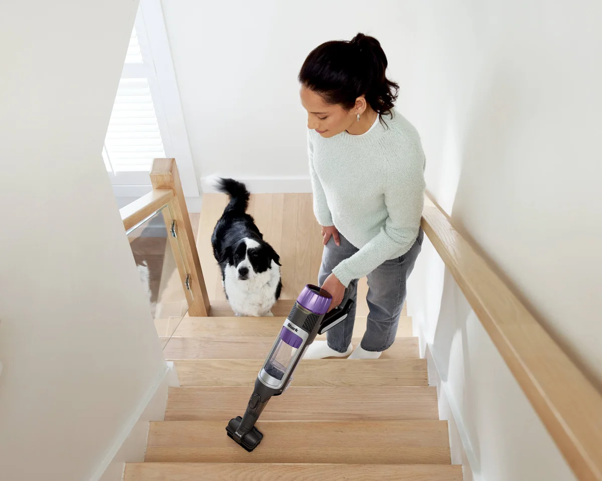 Shark PowerDetect Clean & Empty used in handheld mode with the pet multi-tool to clean wooden stairs