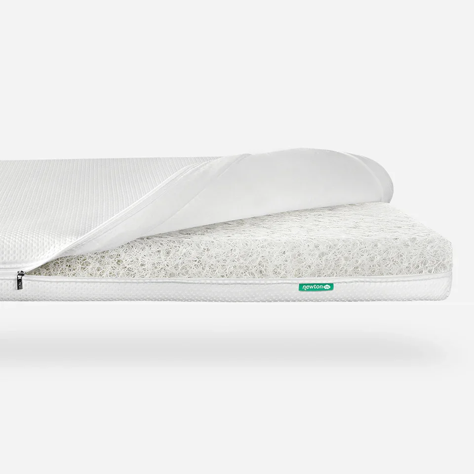 Newton Baby Essential Crib Mattress with cover unzipped showing Wovenaire polymer core