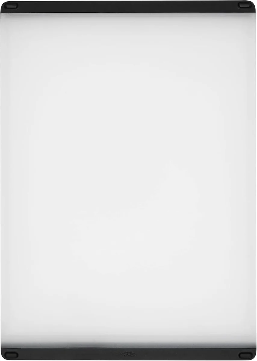 OXO Good Grips Utility Cutting Board shown front-facing on a white background, displaying the full rectangular plastic board with black non-slip edges