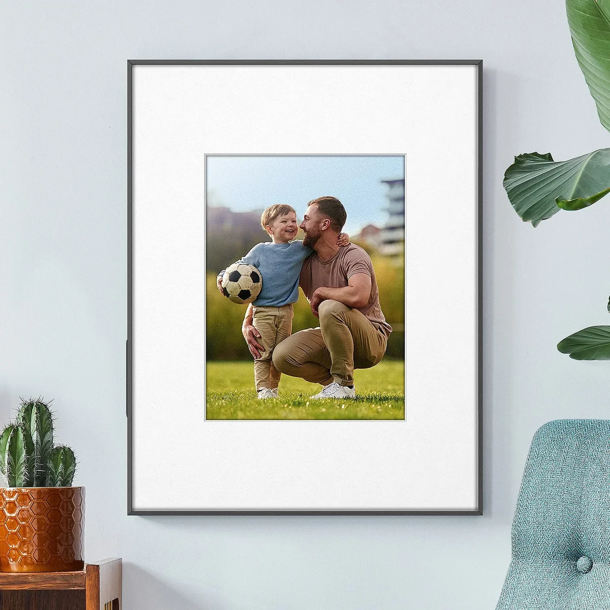 Aluratek ePaper frame wall-mounted showing a father and son playing in a park