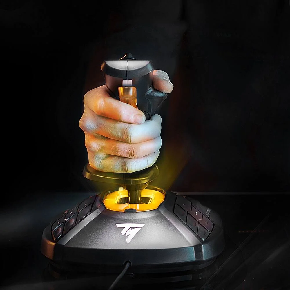 Thrustmaster T.16000M FCS joystick held in hand in a dark cockpit setting