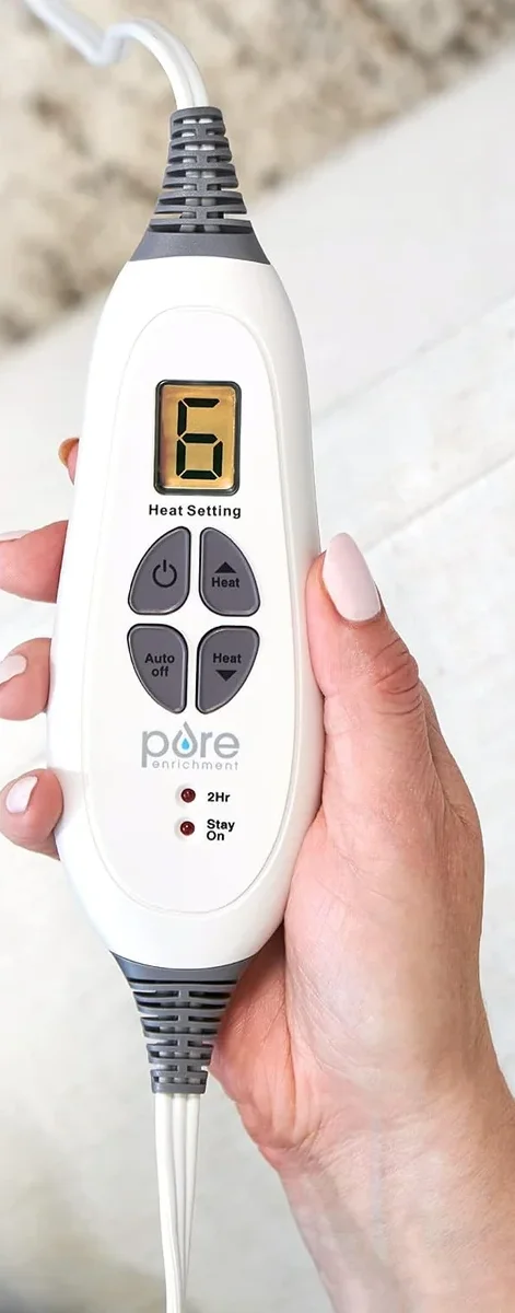 Close-up of the Pure Enrichment PureRelief XL controller held in hand showing the heat setting display and Auto Off button