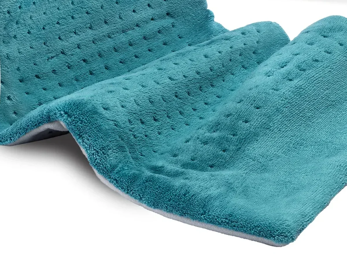 Close-up of the Pure Enrichment PureRelief XL heating pad's plush microplush fabric and perforated heat vents, folded to show texture