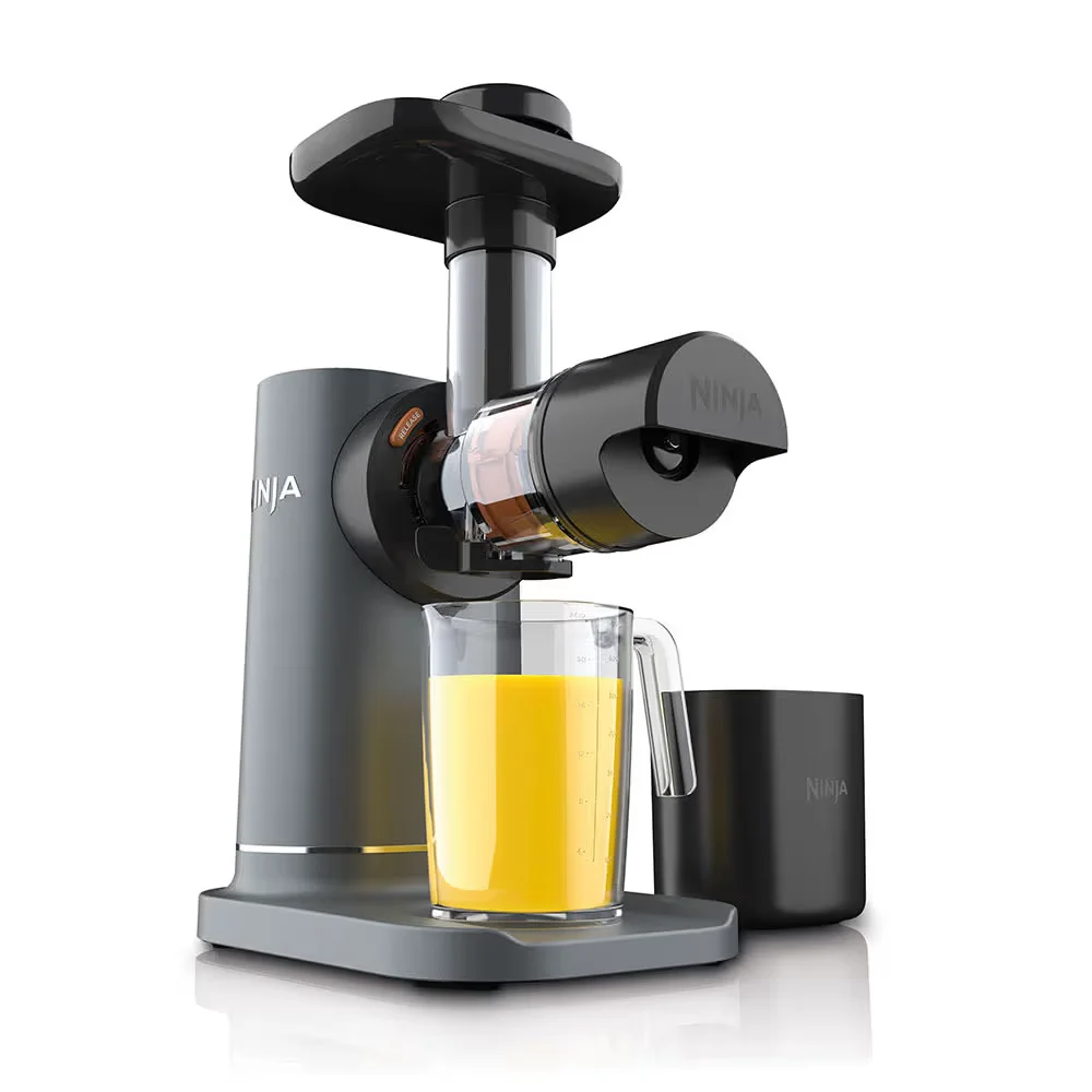 Ninja NeverClog Cold Press Juicer JC151 shown from the front with fresh orange juice filling the collection jug