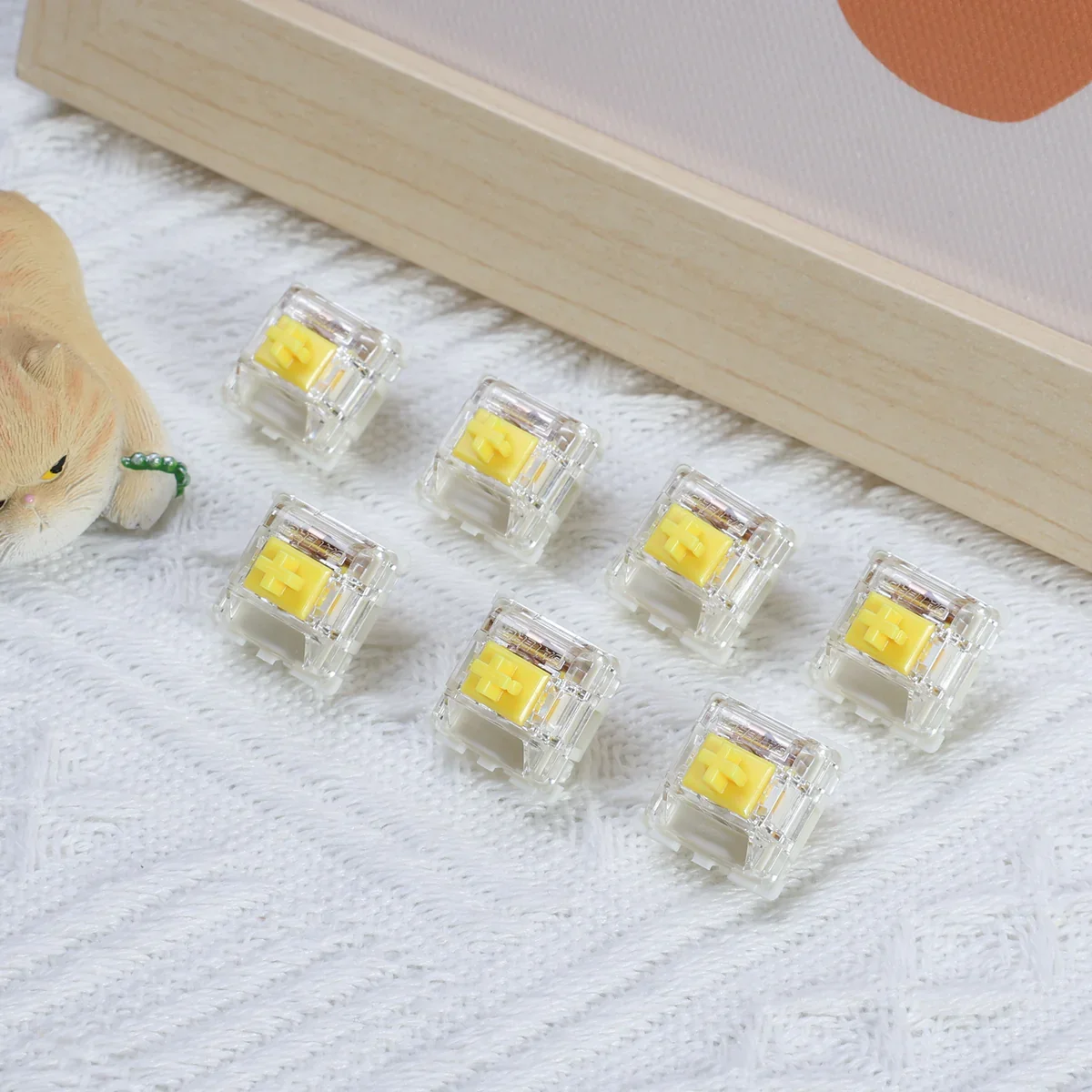 Gateron G Pro Yellow seven switches arranged on fabric surface showing translucent clear housing