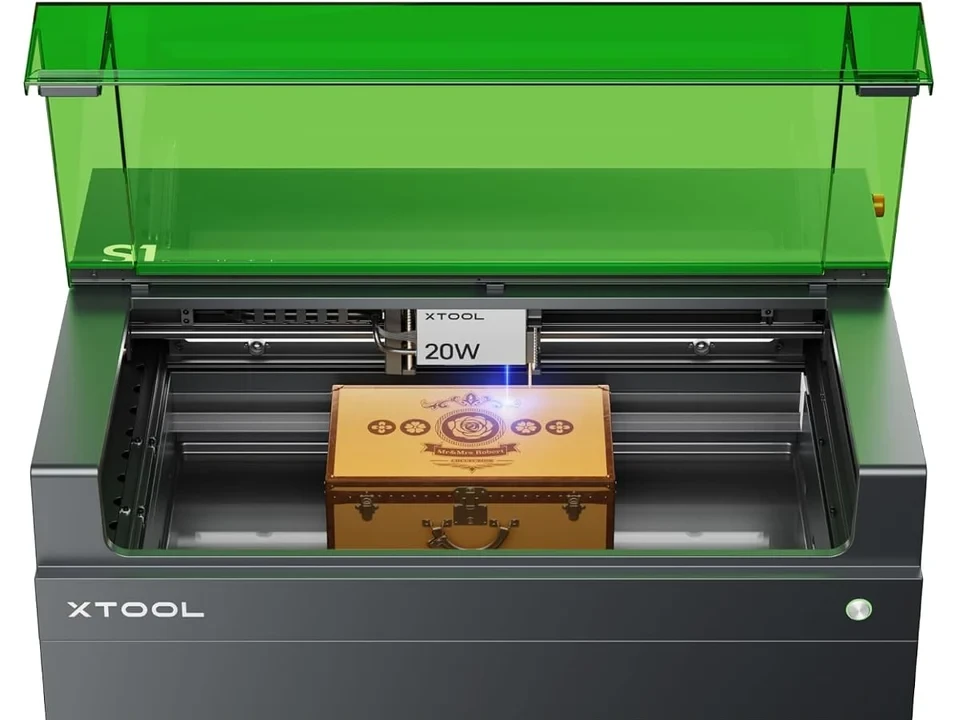 xTool S1 with lid open showing the interior gantry and laser module actively engraving a wooden box