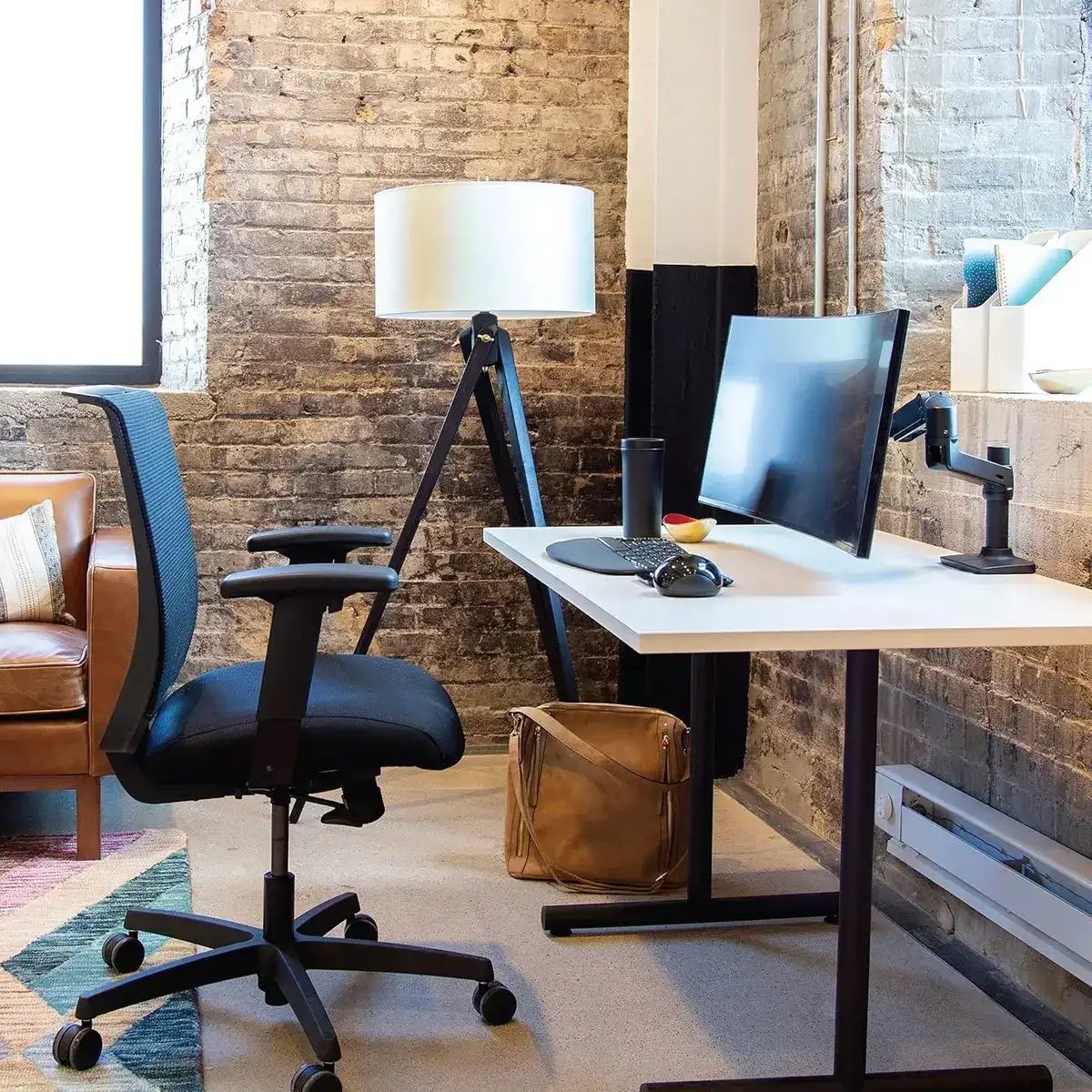 Ergotron LX Desk Mount Monitor Arm in a modern office lifestyle setting with desk and chair