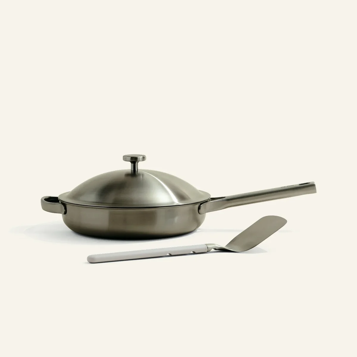 Our Place Titanium Always Pan Pro in brushed titanium with domed lid and matching spatula on a clean background