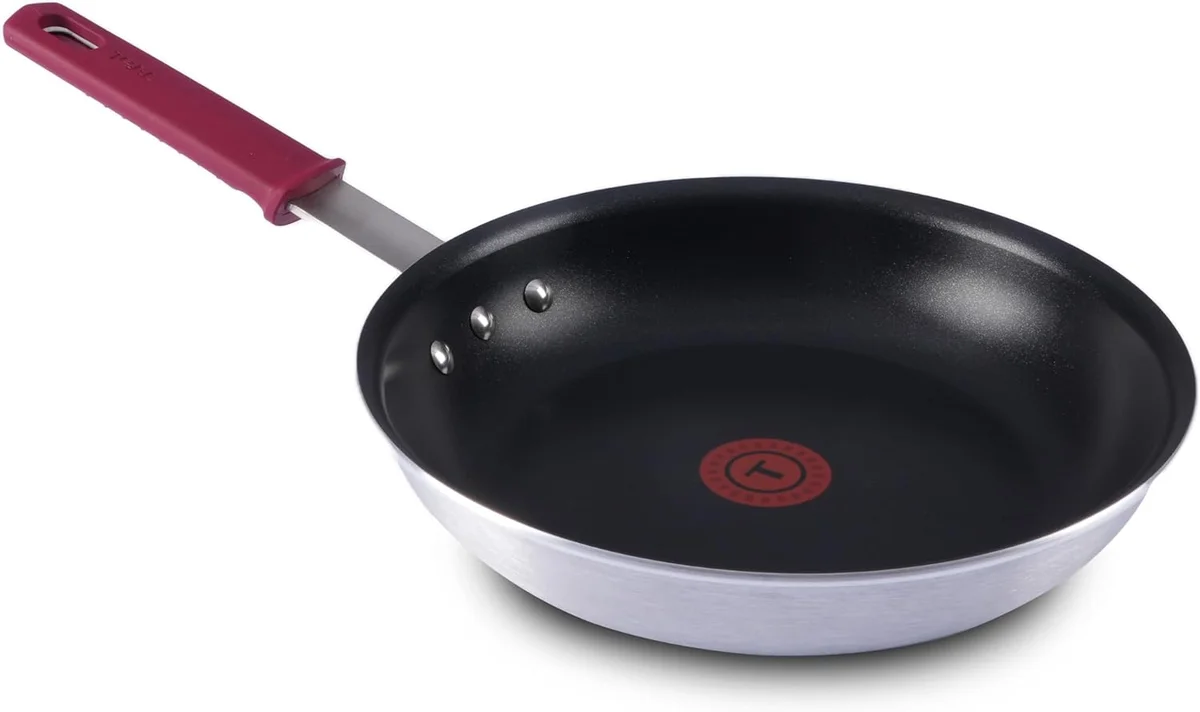 T-fal Titanium nonstick fry pan viewed at an angle, showing the black nonstick interior and red silicone handle grip