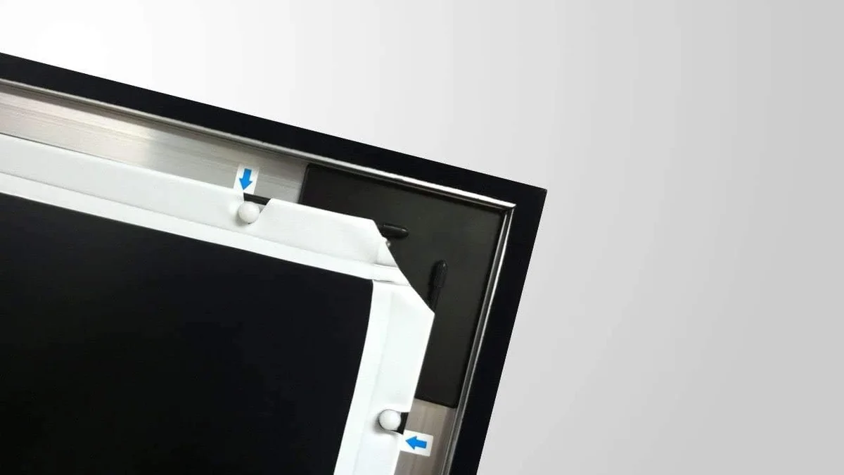 Silver Ticket STR-169120 frame corner detail showing black aluminum extrusion and white matte screen surface with tensioning rod