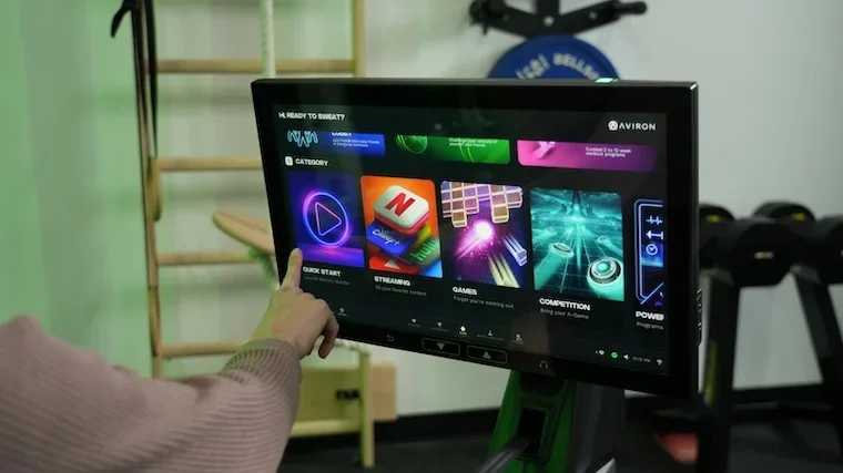 Aviron Strong Series 22-inch touchscreen showing gamified content menu