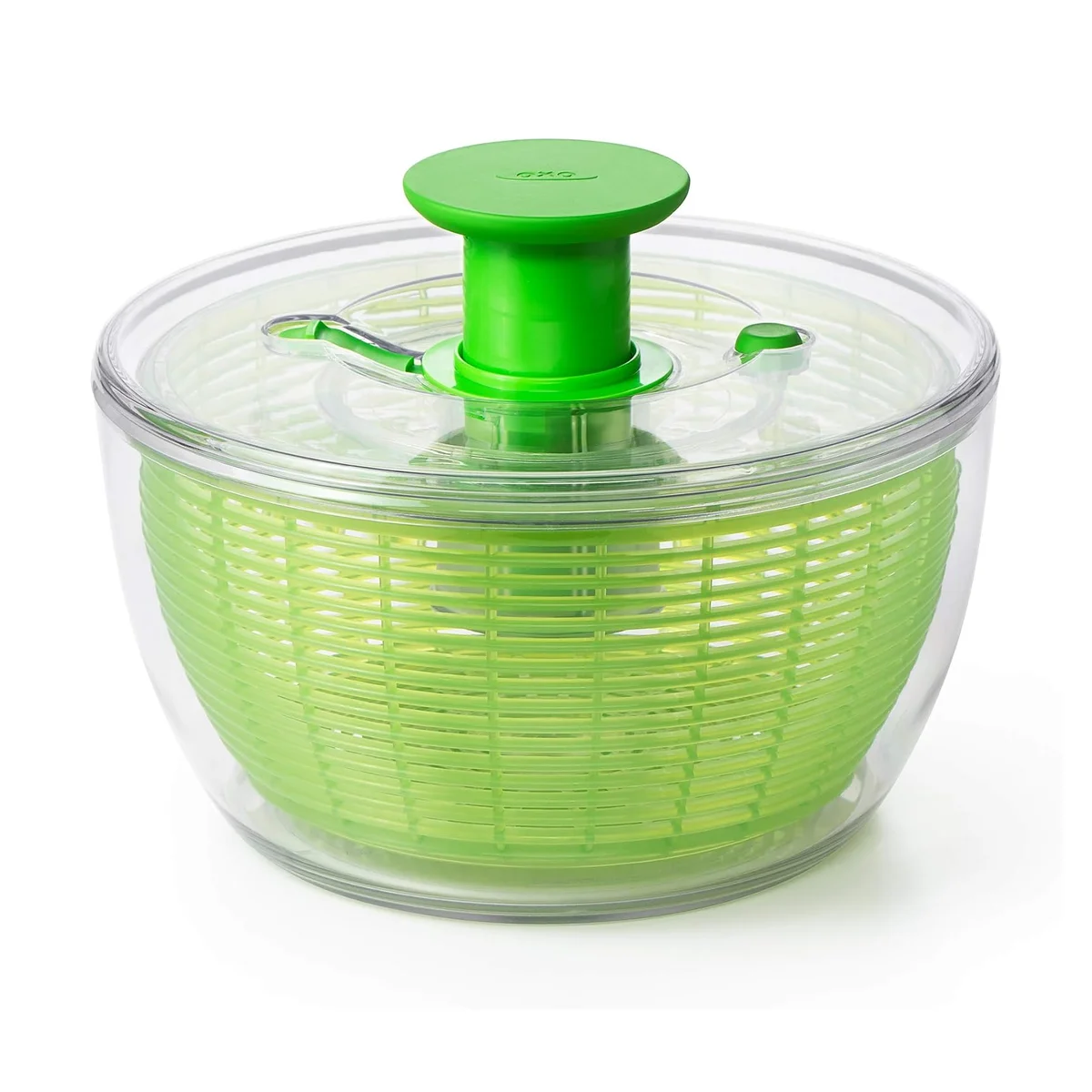 OXO Good Grips Salad Spinner in green, three-quarter view showing the green pump knob and basket inside the clear bowl