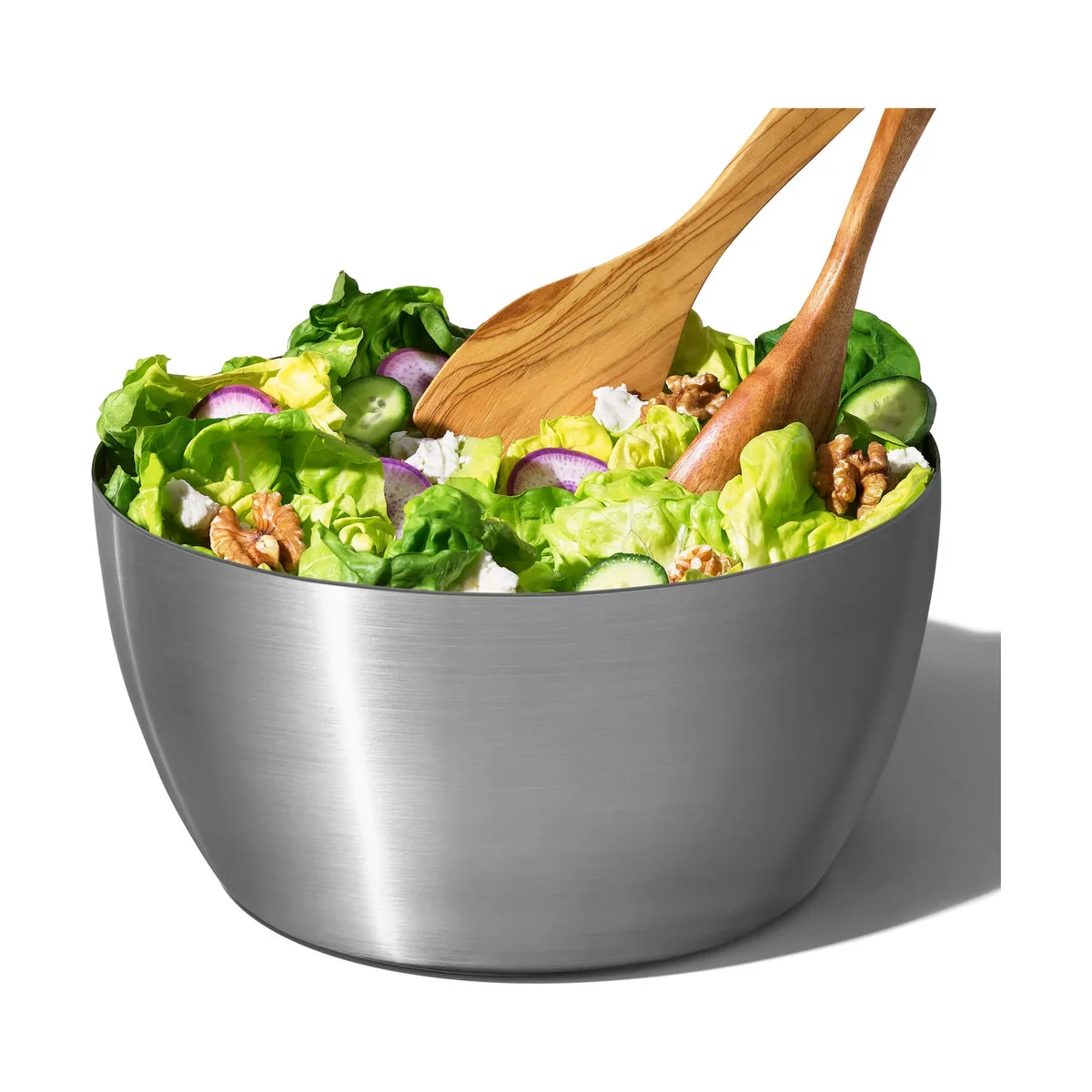 OXO Steel Salad Spinner stainless steel bowl used as a serving bowl, filled with butter lettuce, radish, cucumber, feta and walnuts with wooden salad servers