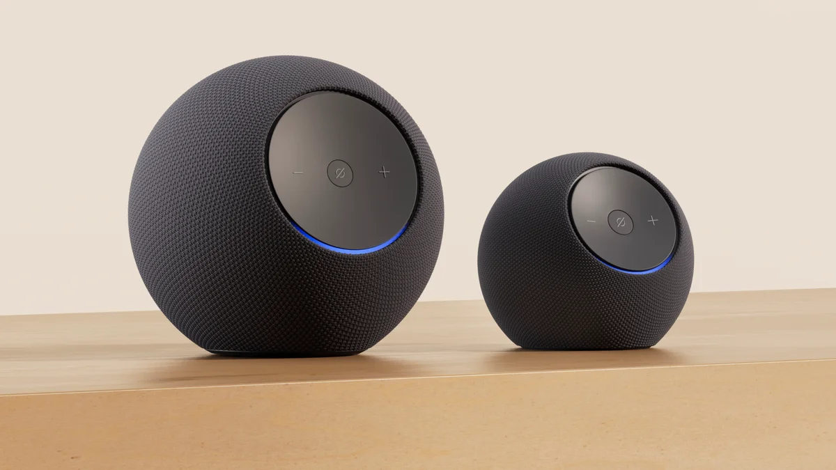 Amazon Echo Dot Max (right) alongside Echo Studio (left) showing relative size on a wooden surface