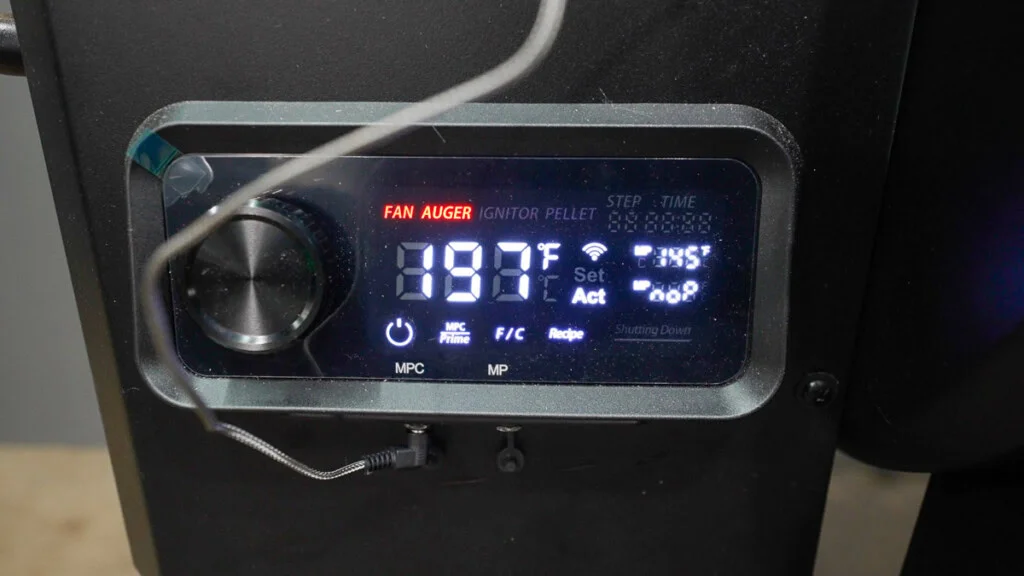 Close-up of the Pit Boss 850 DX's digital PID control panel with dial, temperature readout, and WiFi/Bluetooth indicator