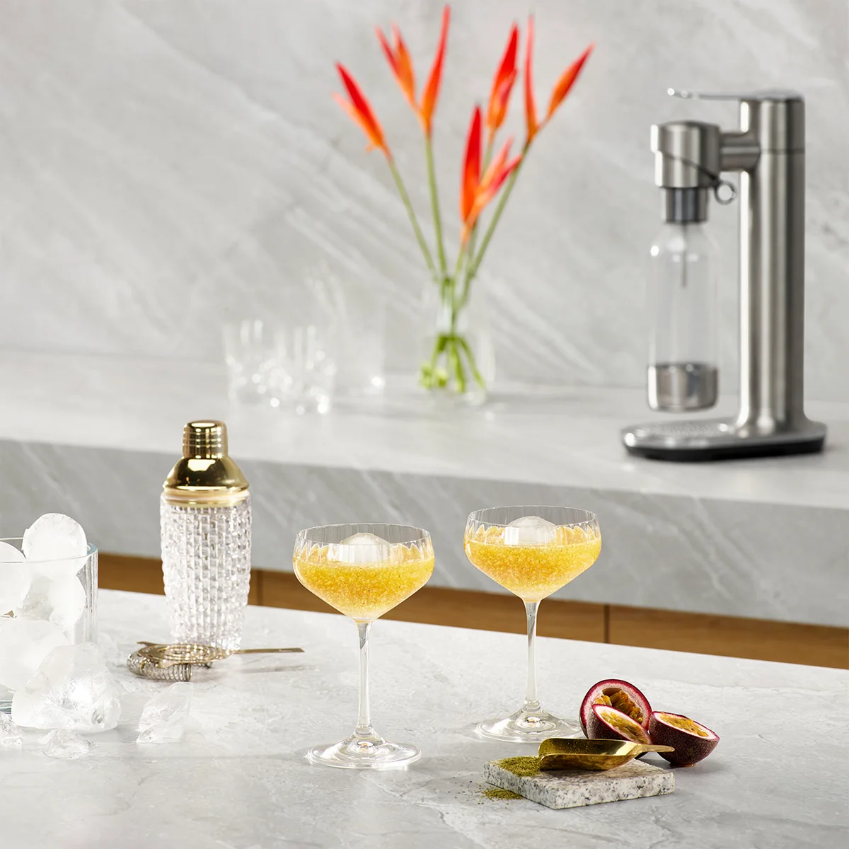 Breville InFizz Fusion on a marble bar counter alongside sparkling passionfruit cocktails