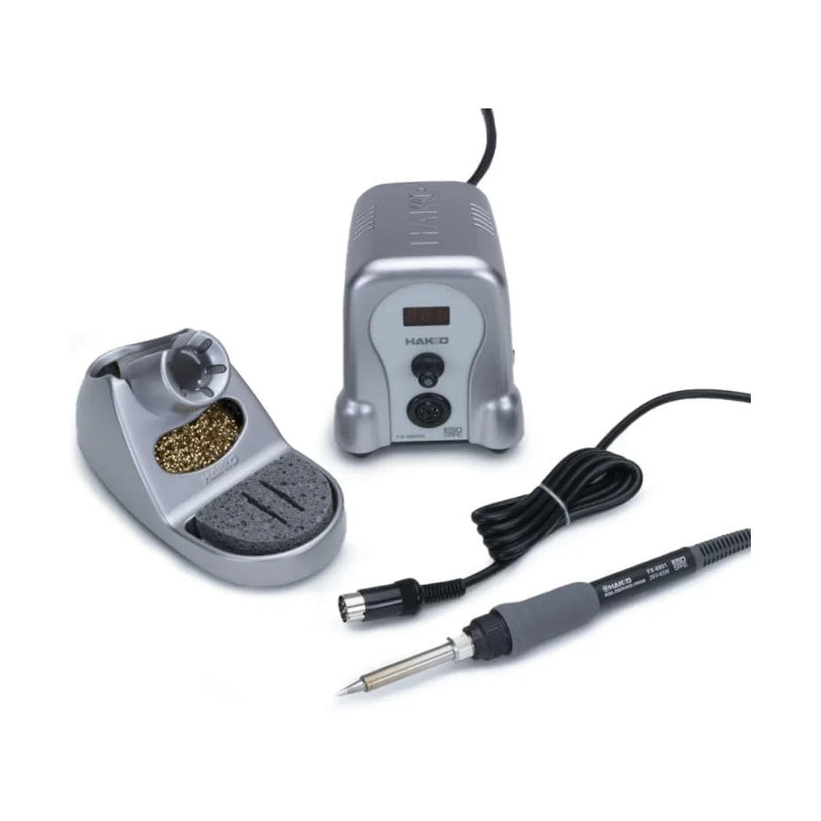 Hakko FX-888D soldering iron handpiece resting in the iron holder with brass cleaning coil