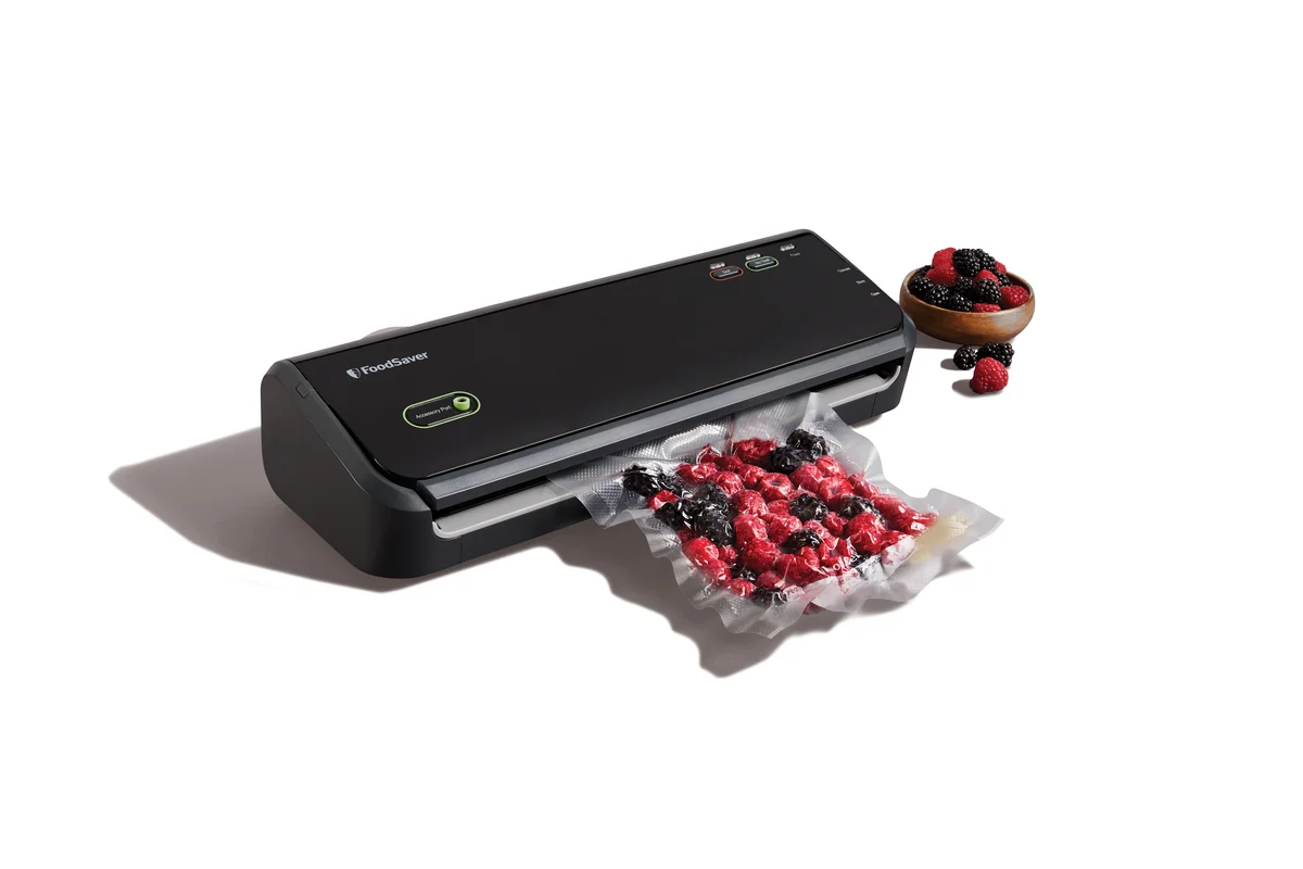 FoodSaver FM2000 styled shot with a vacuum-sealed bag of mixed berries and a bowl of fruit